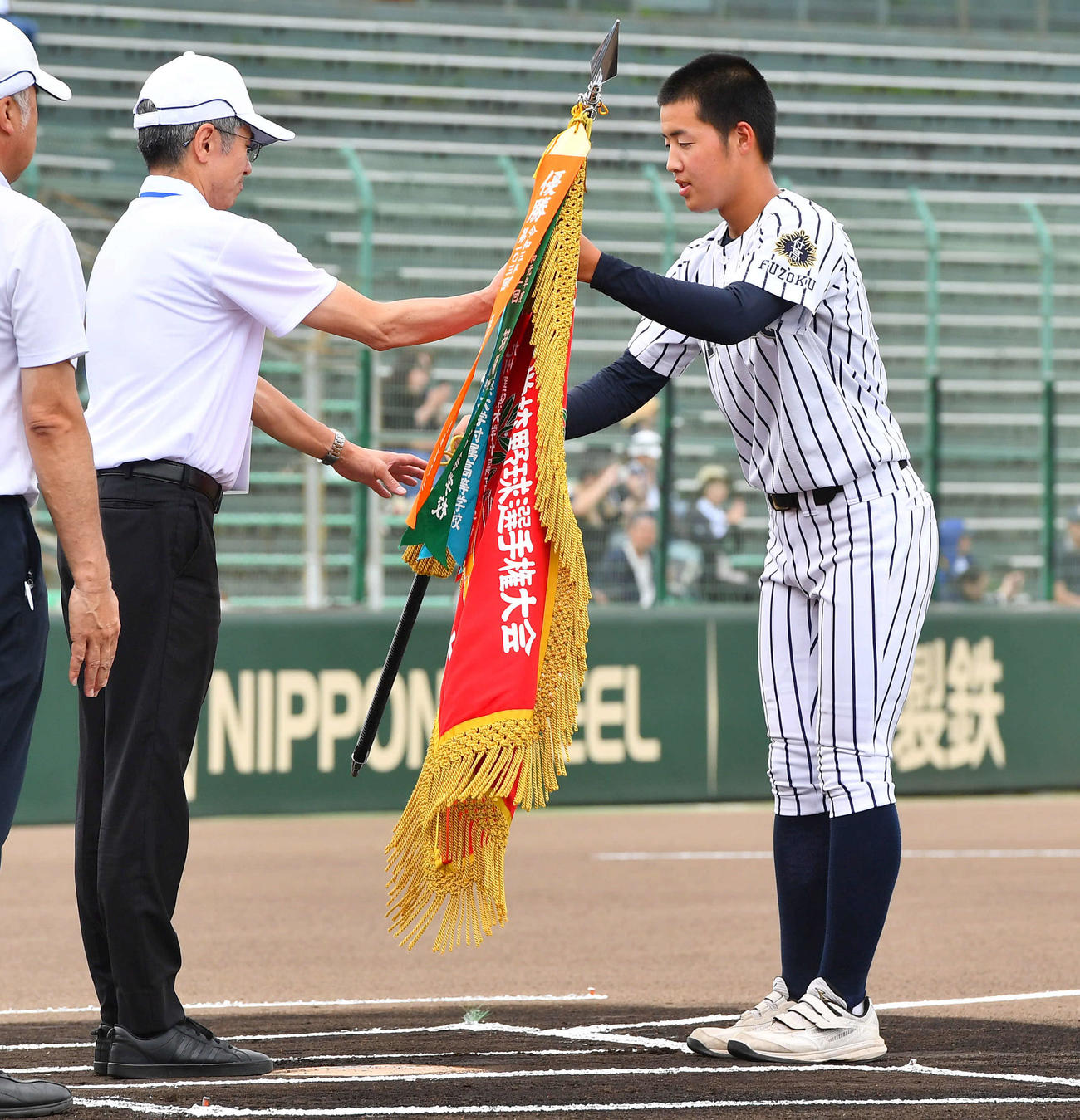 高校野球福岡大会の開会式で優勝旗の返還を行う九州国際大付・田端主将（撮影・岩下翔太）