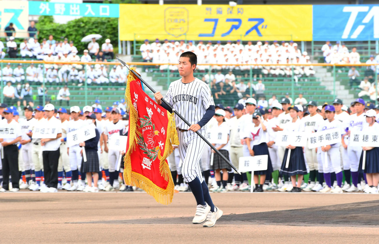 高校野球福岡大会の開会式で優勝旗の返還を行う九州国際大付・田端主将（撮影・岩下翔太）