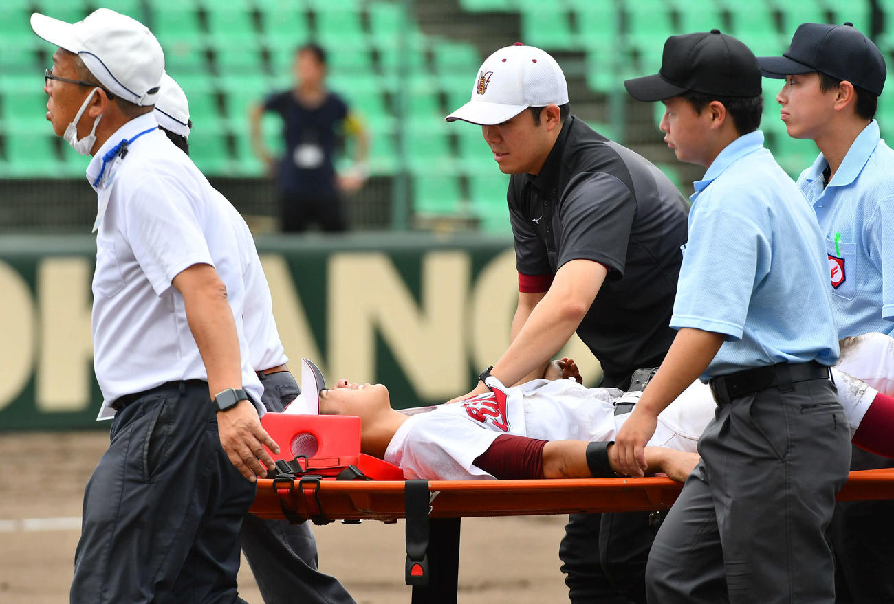 玄界対北九州　6回表玄界1死二塁、平田の打球処理の際に左肩を痛め、担架で運ばれる塚本（撮影・岩下翔太）