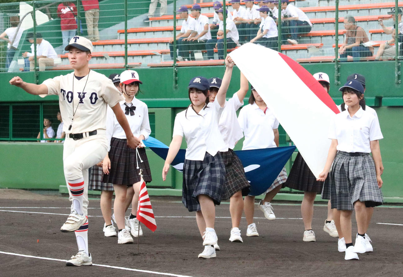 開会式の入場行進で明石市内にある出場校のマネージャーとともに先導する東洋大姫路の副主将・桐田（左）（撮影・塚本光）