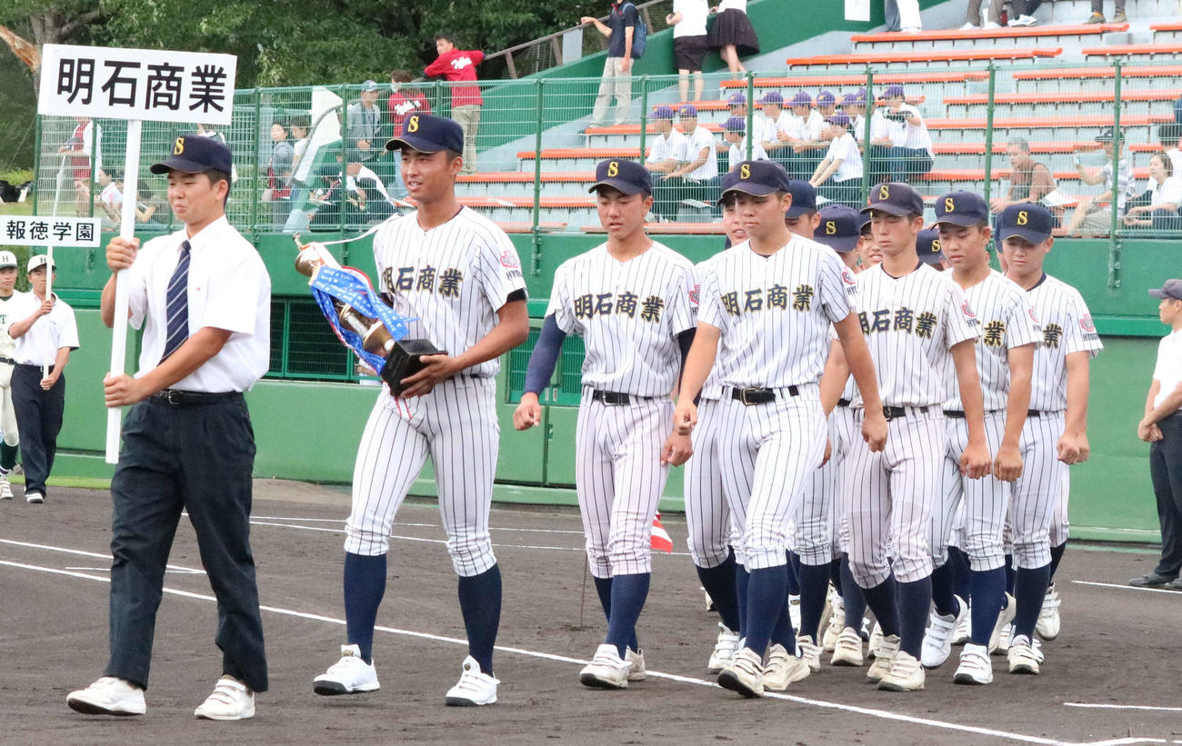 第106回全国高校野球選手権兵庫大会　開会式で主将の山内（左から2人目）が準優勝のトロフィーを持ち2校目の入場行進を行った明石商（撮影・塚本光）