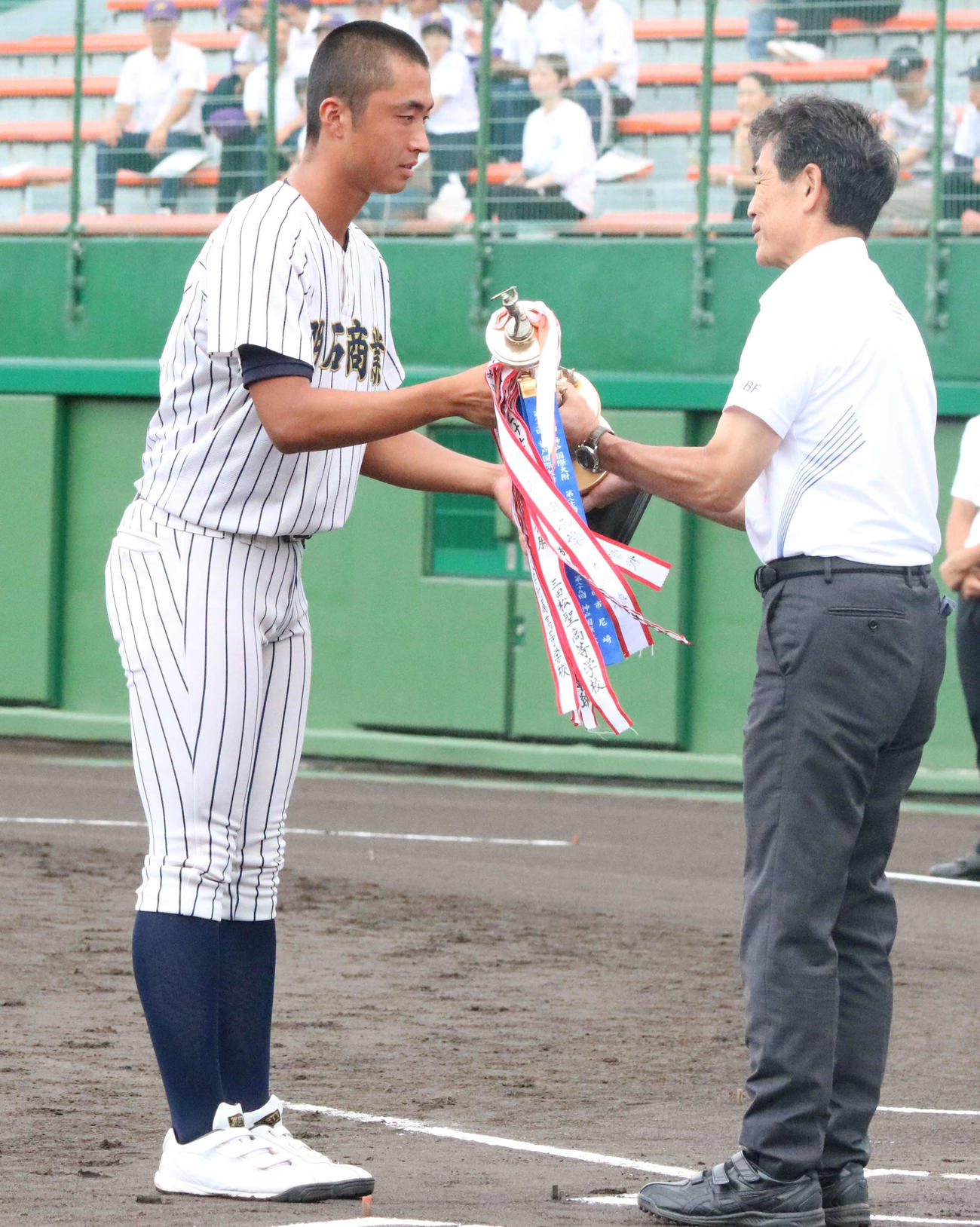 開会式で準優勝のトロフィーを返還した明石商の主将・山内（左）（撮影・塚本光）