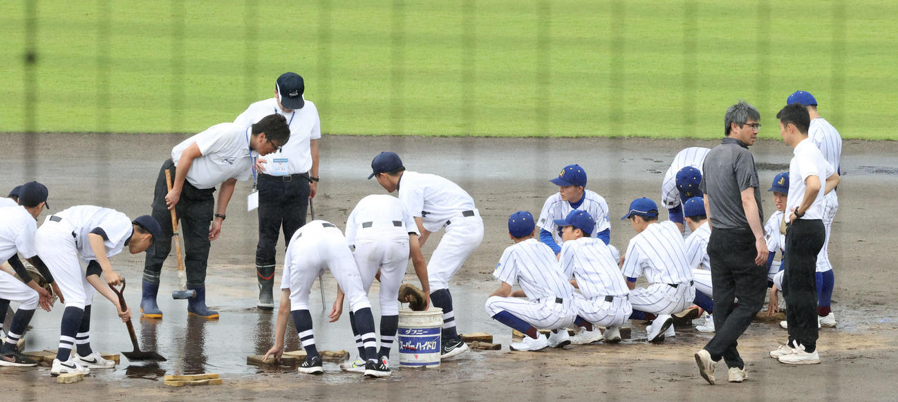福岡対純真　試合前に激しい雨が降りグラウンドを整備する両校のナイン（撮影・梅根麻紀）