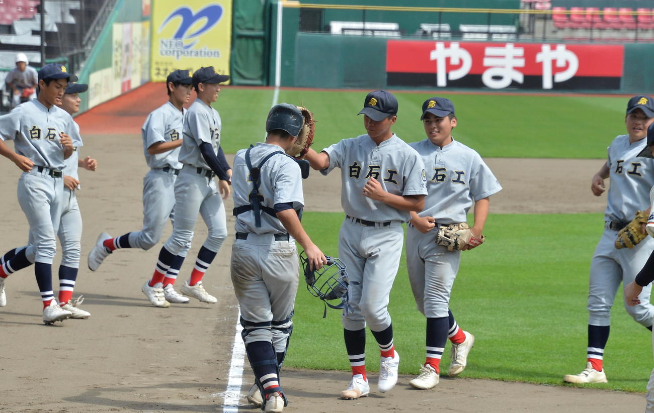 白石工対佐沼　開幕試合を勝利し、グラブでハイタッチする白石工・佐藤大（中央右）と黒田（中央左）（撮影・濱本神威）