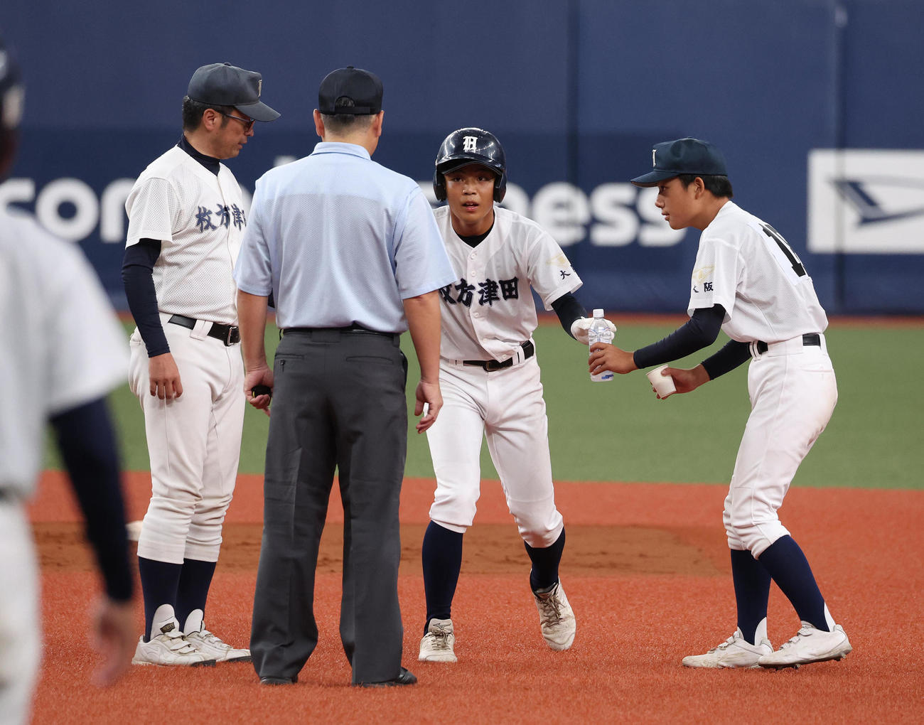 交野対枚方津田　8回裏枚方津田1死一、二塁、福山雄大は藤原幸大郎の内野安打で進塁するも二塁で足がつり水分補給する。左は見守る荒野博司監督（撮影・白石智彦）