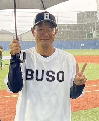 雨の中で傘をさす武相の豊田監督（本人提供）