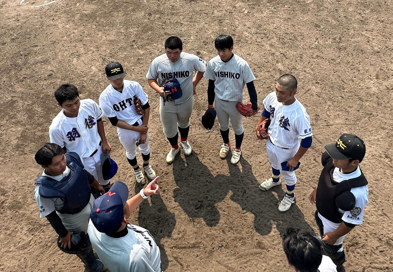 佐藤俊平監督（手前）の話を聞く男鹿海洋・仁賀保・西仙北・大曲農高太田分校・雄物川・羽後連合の選手たち