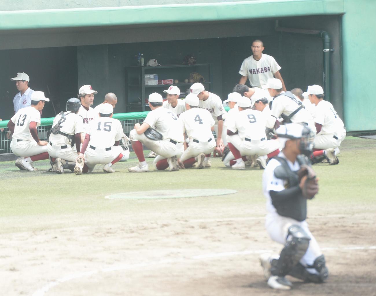 育徳館対福岡大若葉　延長10回裏タイブレーク前に選手を集め、助言を送る福岡大若葉・土井監督（中央）（撮影・佐藤究）