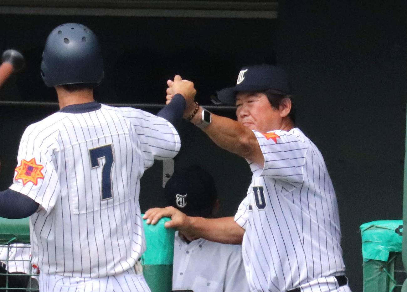 東北対石巻工　1回表東北1死三塁、左犠飛で生還した布川（左）とグータッチを交わす佐藤監督（撮影・黒須亮）　