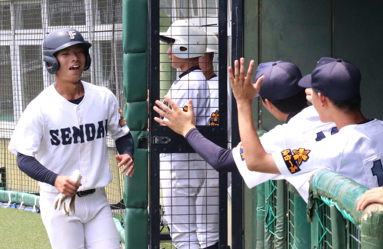 仙台一－利府　1回表仙台一1死三塁、小川の適時二塁打で生還した小嶋がチームメートに迎えられる（撮影・黒須亮）