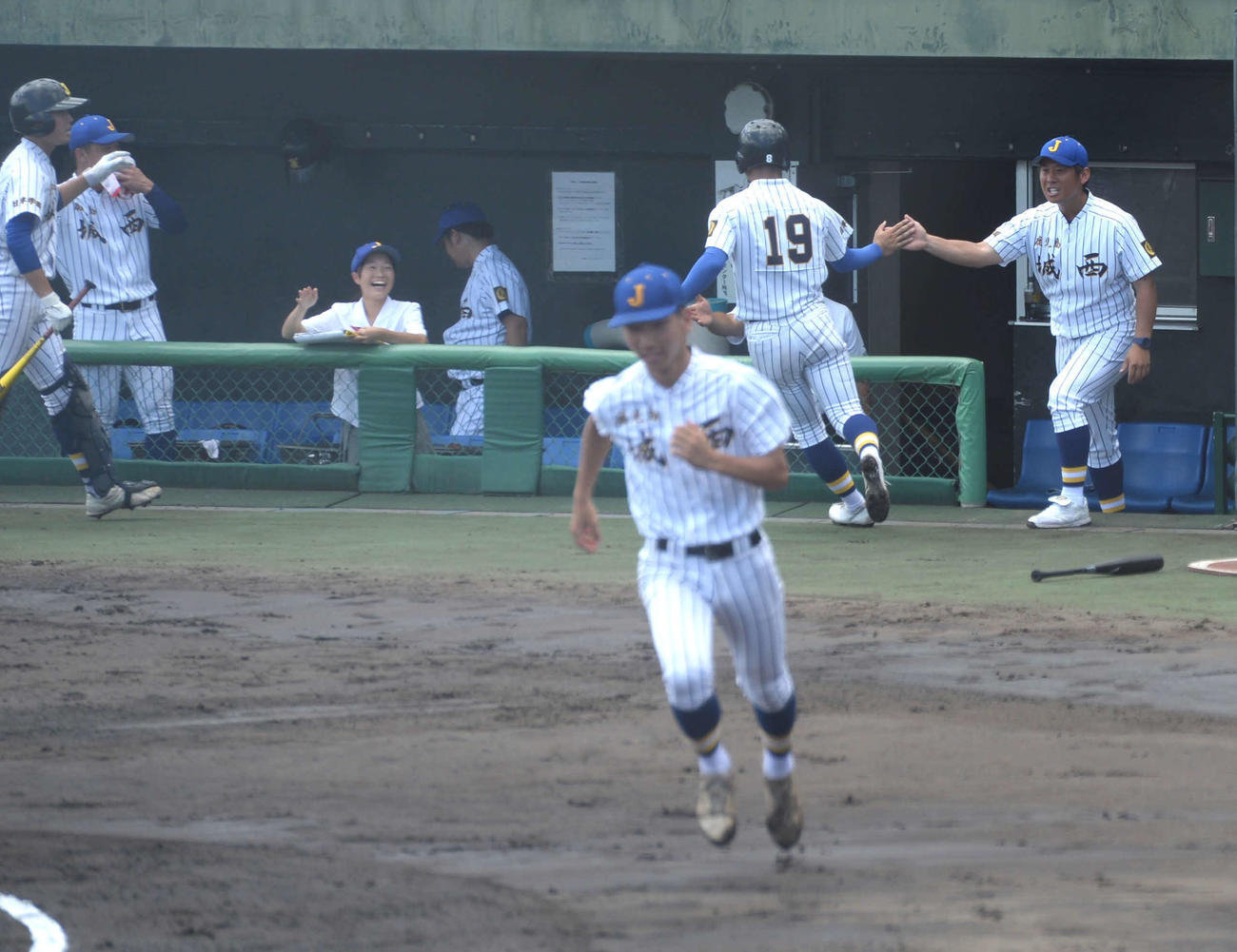 鶴丸対鹿児島城西　初回に先制し、選手とハイタッチする鹿児島城西・道端監督（右）（撮影・佐藤究）