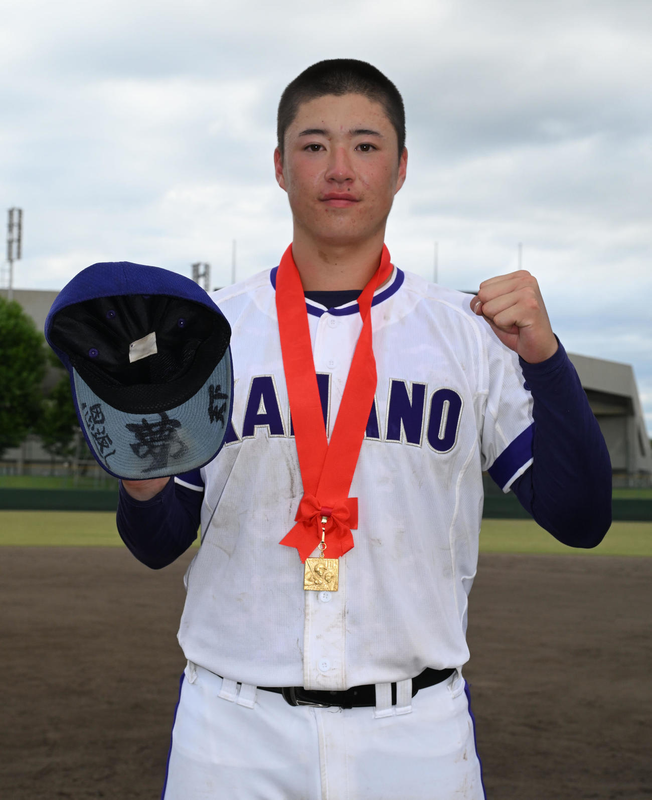 全国高校野球秋田県大会　秋田商対金足農　優勝メダルを首にかけ、帽子のつばの裏に書かれた抱負を披露する金足農・吉田投手（撮影・千葉一成）