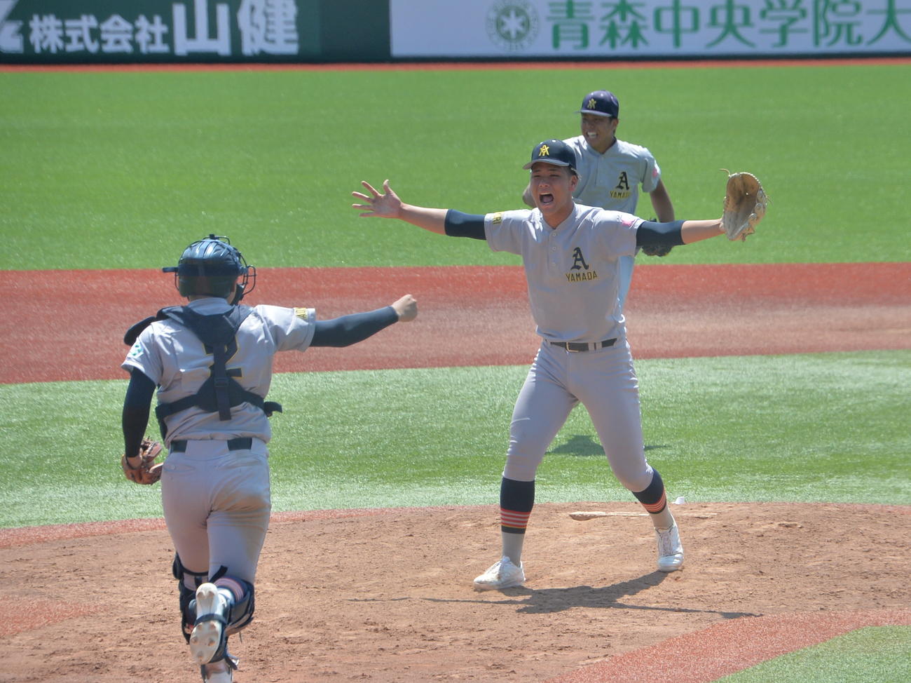 弘前学院聖愛対青森山田　最後の打者を空振り三振に抑えた青森山田・関（左）は両手を広げて橋場を迎える（撮影・濱本神威）