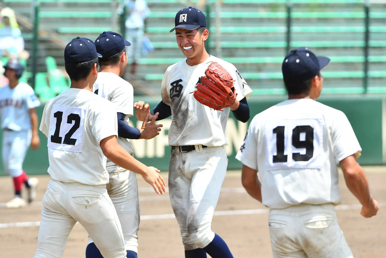 西日本短大付対近大福岡　最終回を抑えて決勝進出を決め、ナインと笑顔でタッチを交わす西日本短大付・村上（撮影・岩下翔太）
