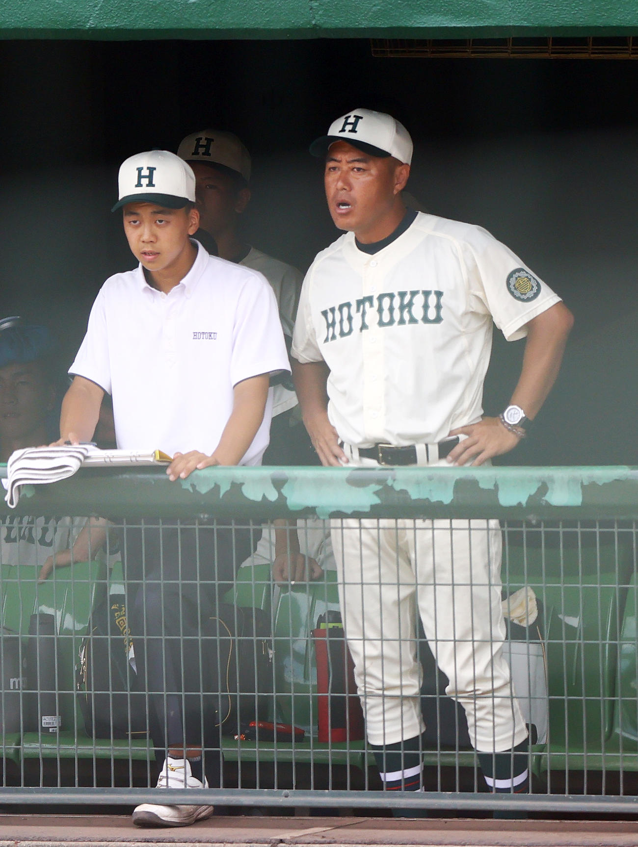 神戸学院大付対報徳学園　6回、ベンチから戦況を見つめる報徳学園・大角監督（右）（撮影・上山淳一）