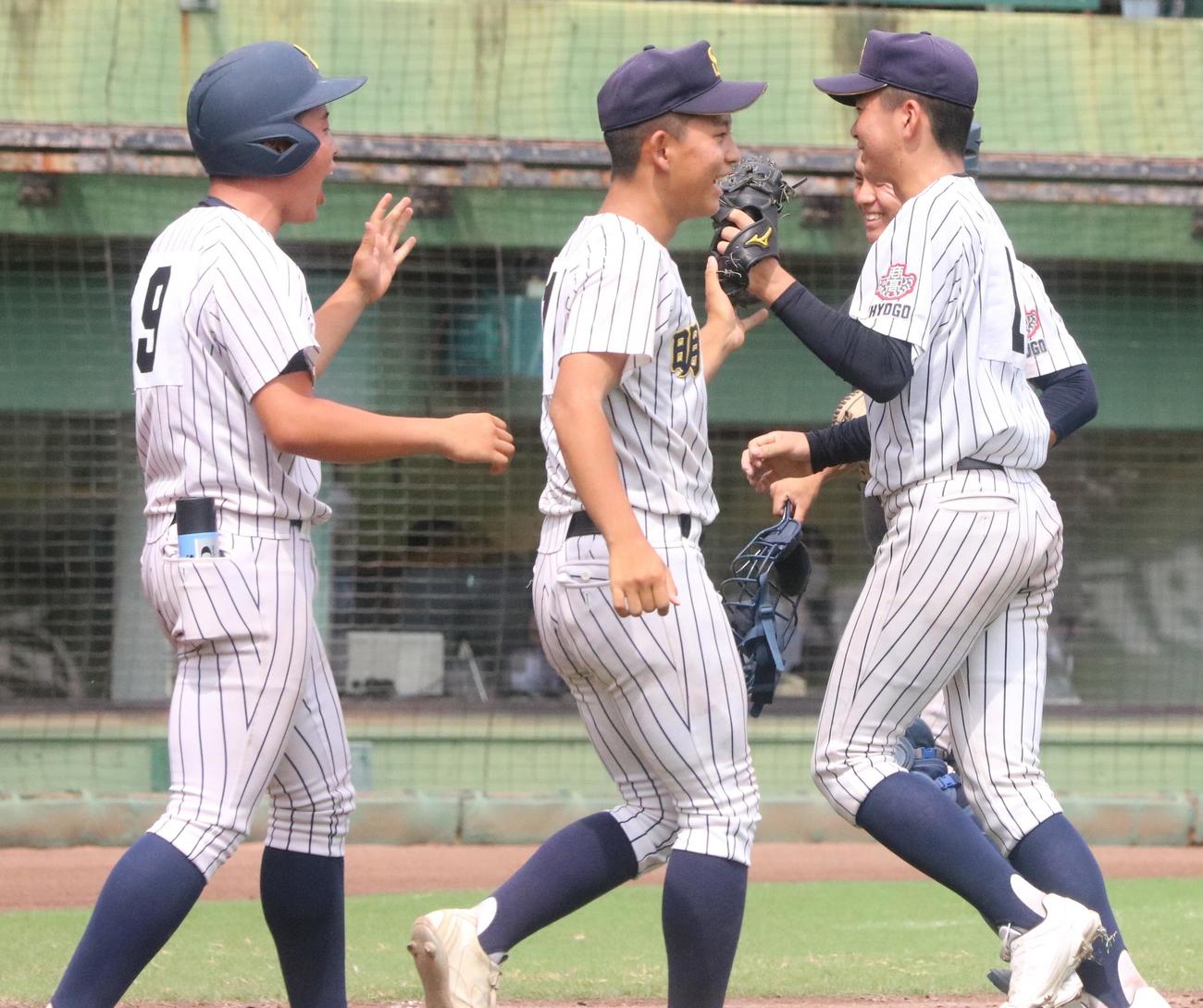明石商対滝川二　8回裏滝川二2死二、三塁、ピンチを抑えベンチの前で仲間に笑顔で迎えられた明石商・横山（撮影・塚本光）