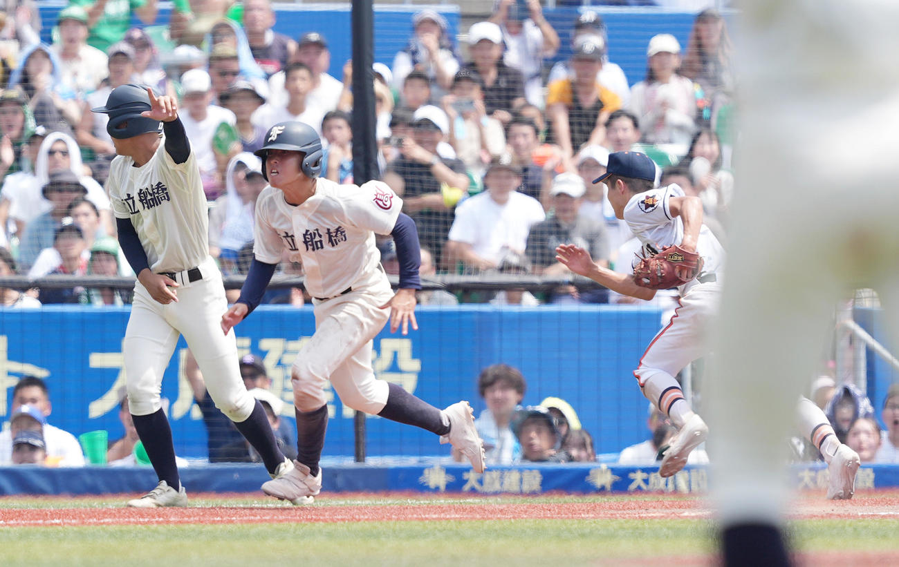 市船橋対木更津総合　10回表市船橋1死二、三塁、捕手羽根からの送球に三塁に帰塁した三塁走者恒田は、ボールがそれて本塁に向かう。右は三塁手和田（撮影・菅敏）