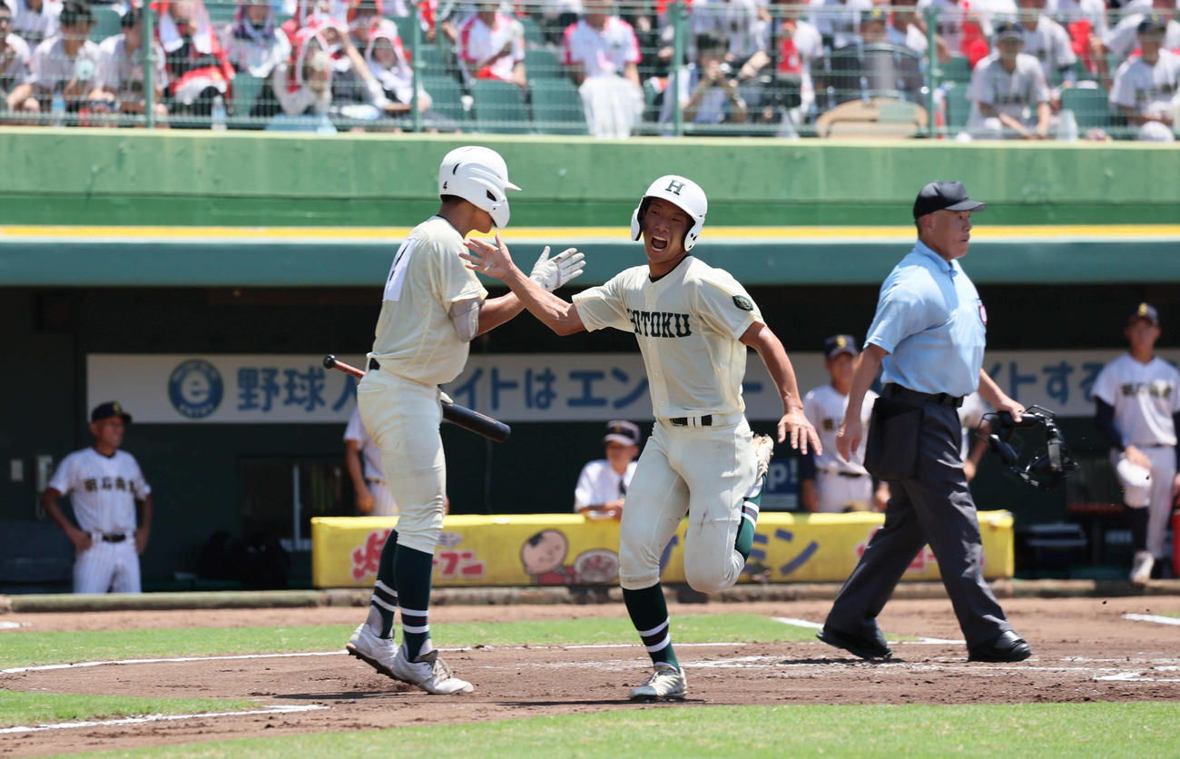 明石商対報徳学園　6回裏報徳学園1死2塁、安井（右）は橋本の右前先制適時打で生還する（撮影・宮崎幸一）