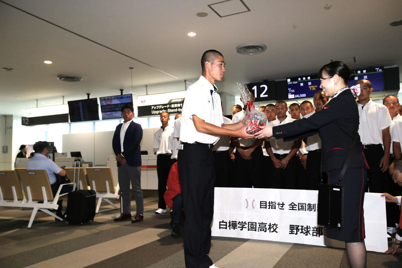 白樺学園の藤原主将（左）は、JALの職員から記念品を受け取る（撮影・中島洋尚）2024年7月31日