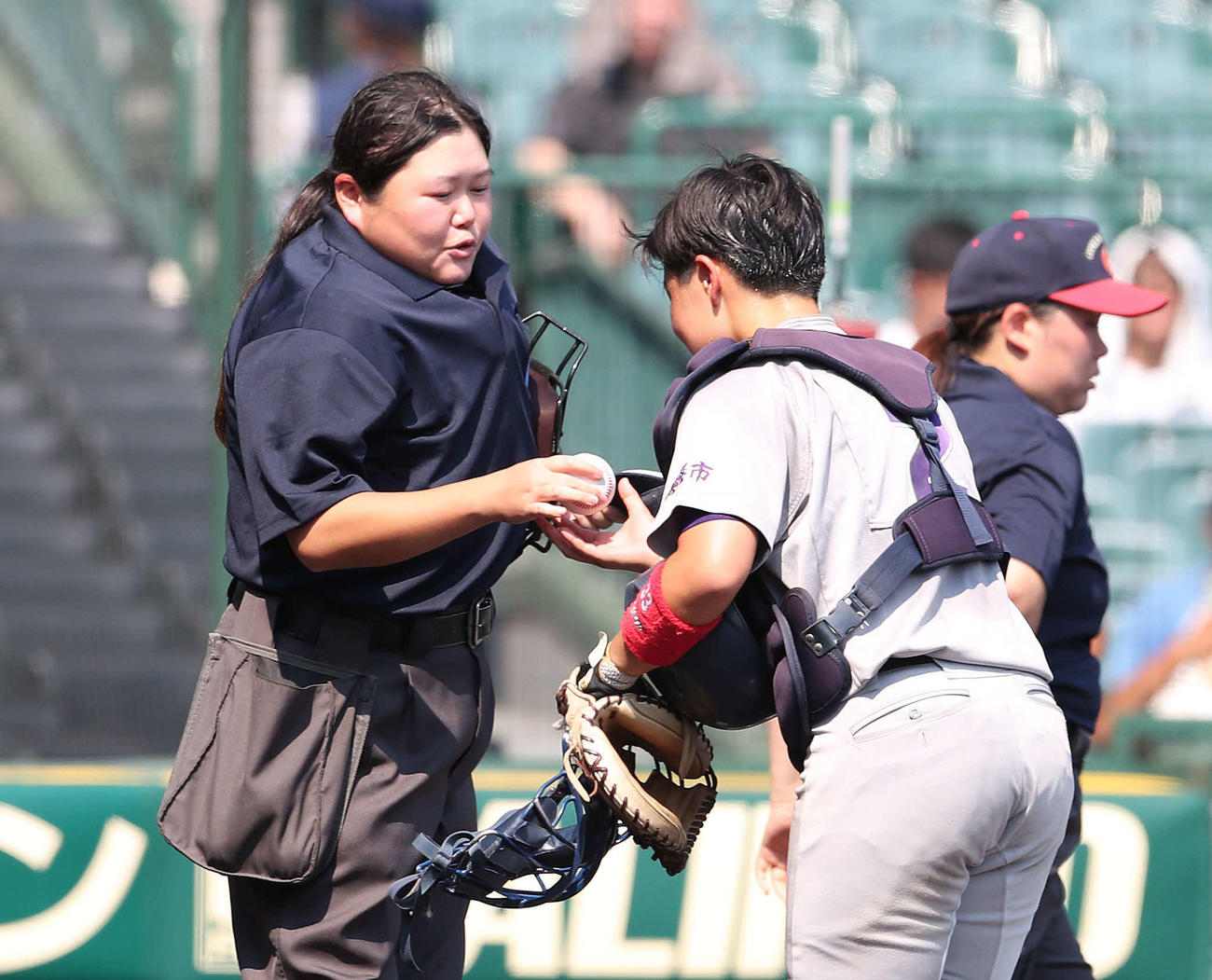 神戸弘陵対花巻東　花巻東の捕手、田垣朔來羽（右）にボールを渡す球審の松田佳奈さん（撮影・白石智彦）