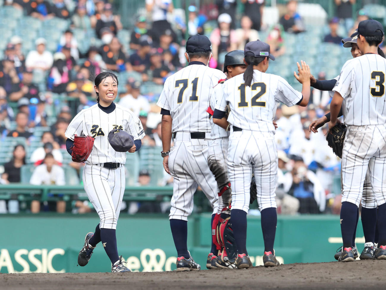 神戸弘陵対花巻東　7回裏花巻東2死、タッチを交わす先発の阿部さくら（右から2人目）と笑顔でマウンドに向かう神戸弘陵・伊藤まこと（左）（撮影・白石智彦）