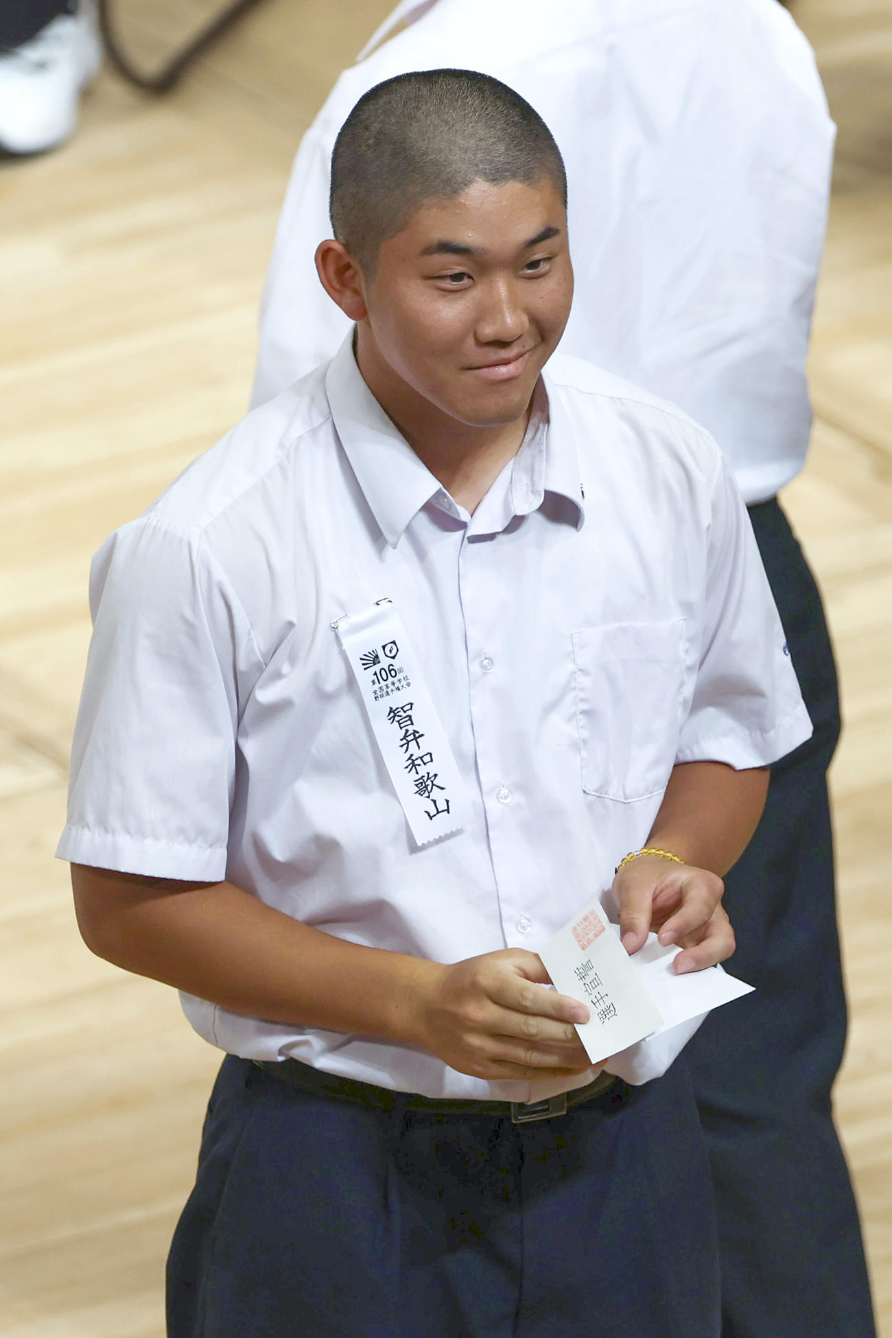 選手宣誓を引き当て笑顔を見せる智弁和歌山・辻主将（撮影・上山淳一）