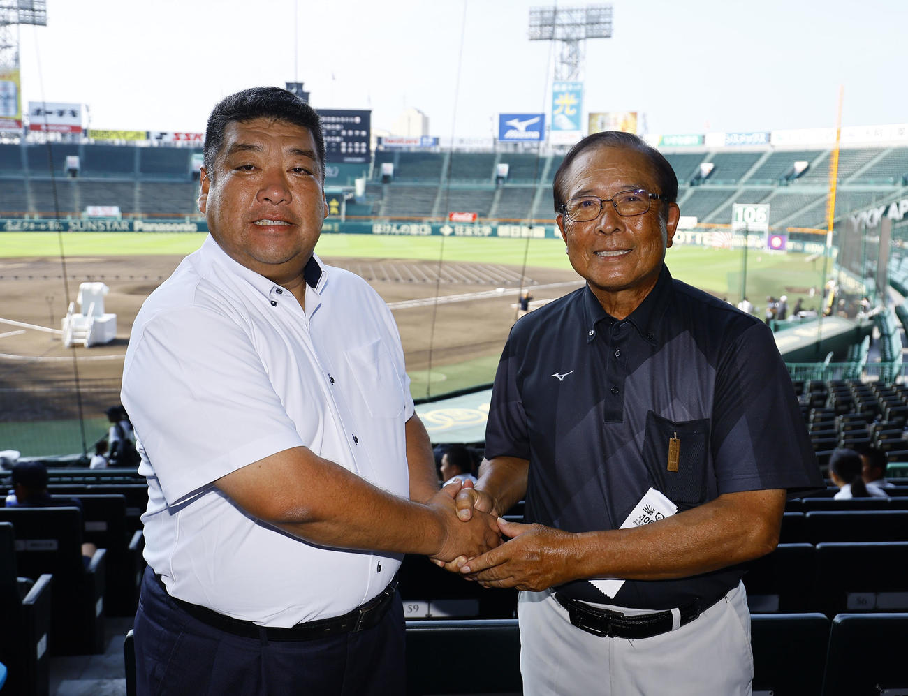 開会式のリハーサルを前に握手を交わす大阪桐蔭・西谷監督（左）と興南・我喜屋監督（撮影・藤尾明華）