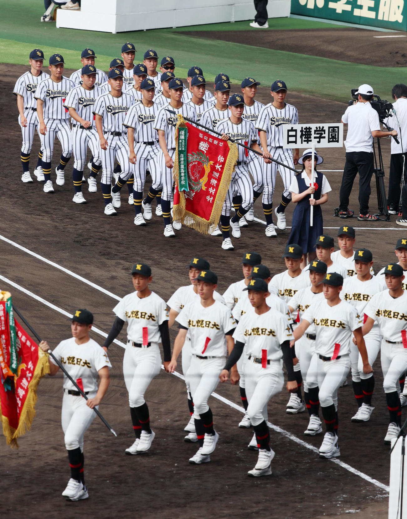開会式のリハーサルで入場行進する札幌日大（手前）と白樺学園ナイン（撮影・加藤哉）
