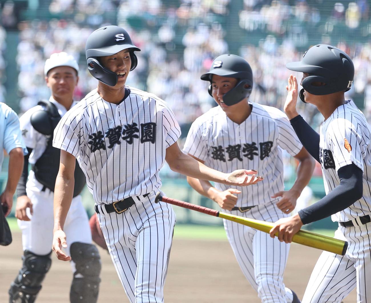 滋賀学園対有田工　1回表滋賀学園1死一、三塁、滋賀学園・岩井（左）は岡田の適時二塁打で生還する（撮影・上田博志）