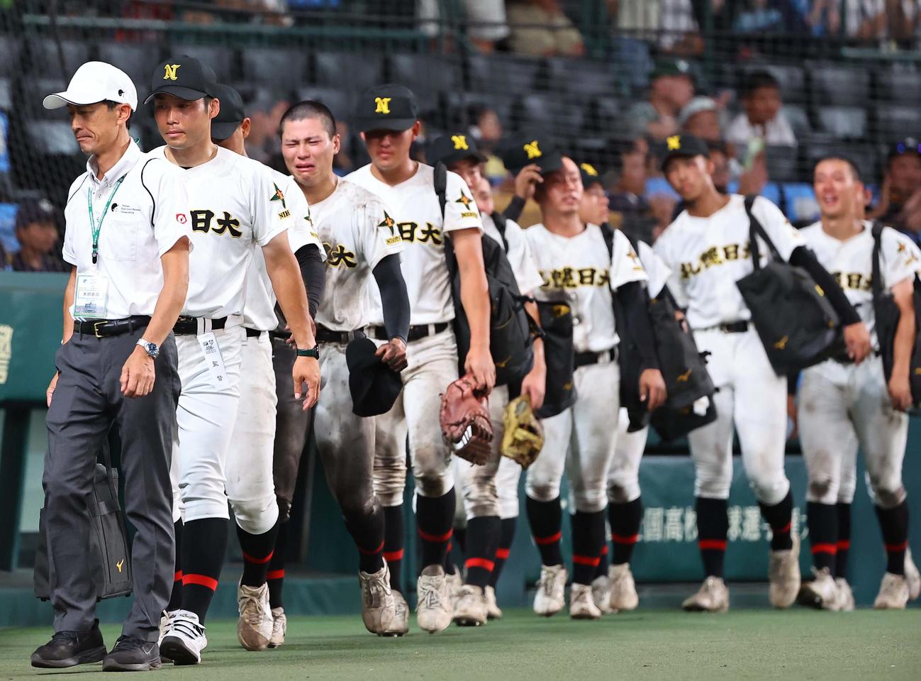 札幌日大対京都国際　札幌日大・森本監督（左から2人目）はナインと甲子園球場を引き揚げる（撮影・上田博志）