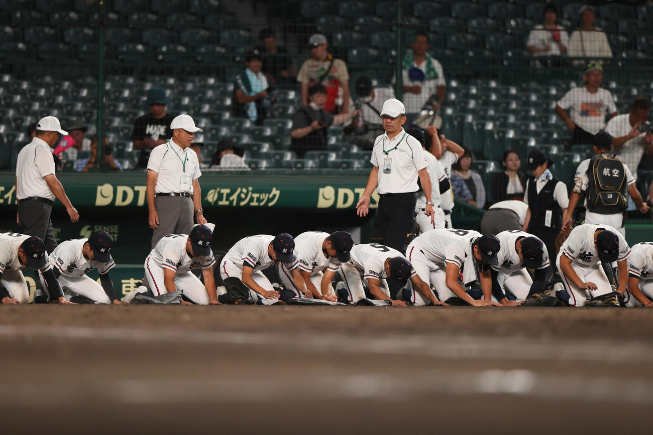 掛川西対日本航空　掛川西に敗れ、甲子園球場の土を拾う日本航空の選手たち（撮影・上山淳一）