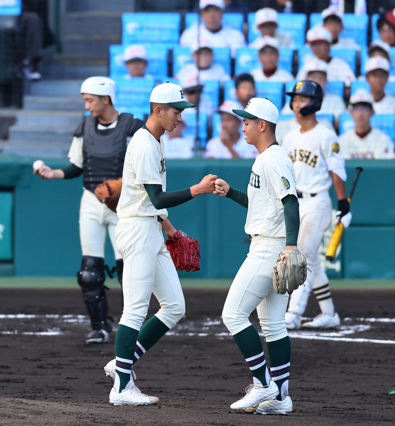 大社対報徳学園　7回途中、間木（右）とグータッチを交わし降板する報徳学園・今朝丸（撮影・藤尾明華）