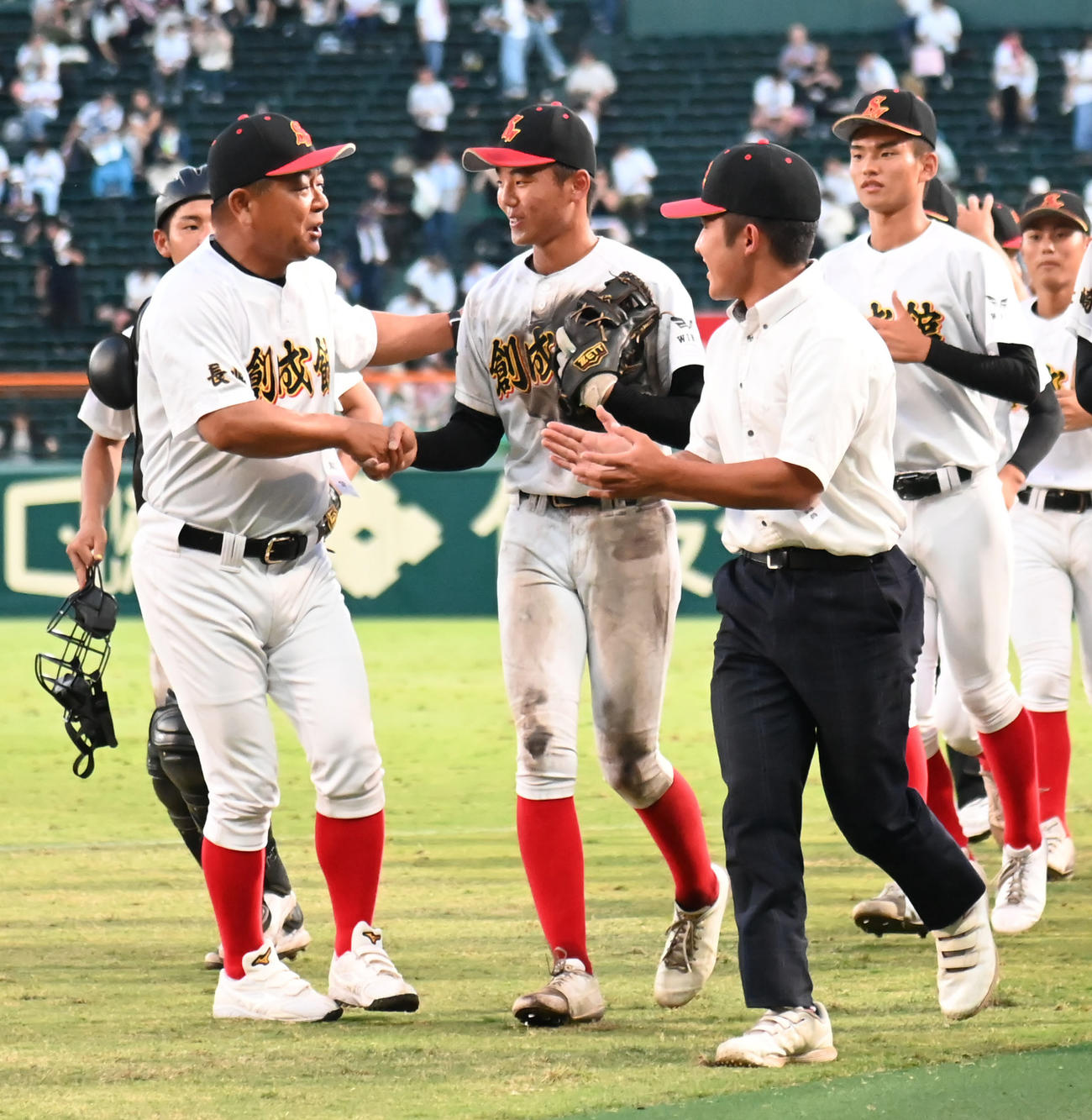 白樺学園対創成館　3回に犠飛を放った向段（中央）と握手を交わす創成館・稙田監督（撮影・石井愛子）