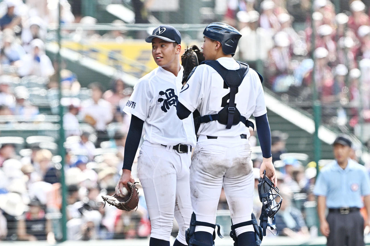 早実対鳴門渦潮　7回表、ピンチにマウンドで話す鳴門渦潮・岡田（左）と藤原（撮影・滝沢徹郎）