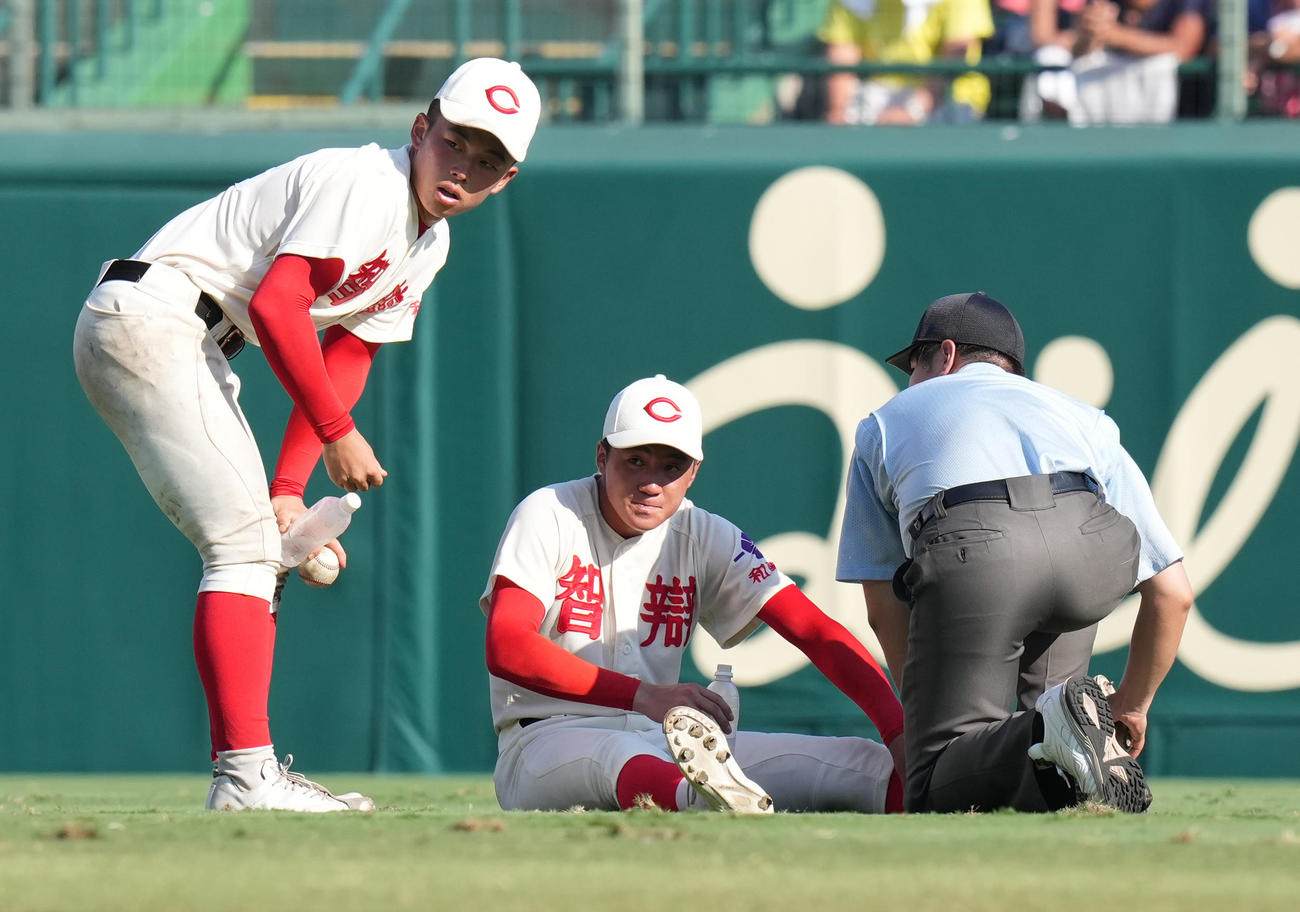 霞ケ浦対智弁和歌山　10回表開始前、足をつる智弁和歌山中堅手藤田（中央）（撮影・鈴木みどり）