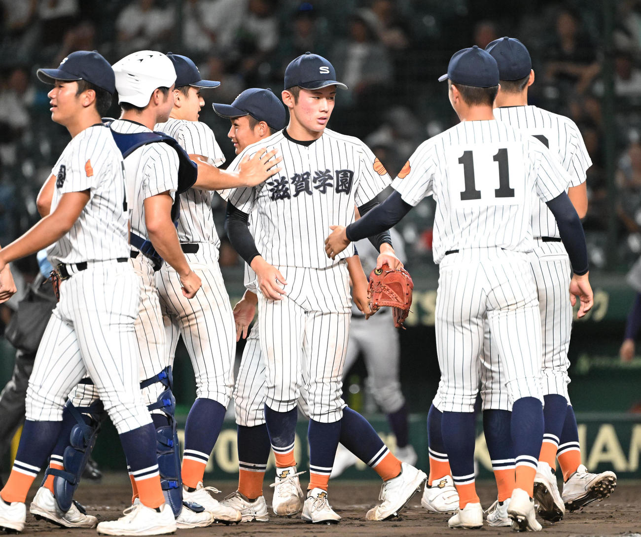 滋賀学園対花巻東　花巻東に完封勝利しタッチを交わす滋賀学園・脇本（中央）（撮影・和賀正仁）