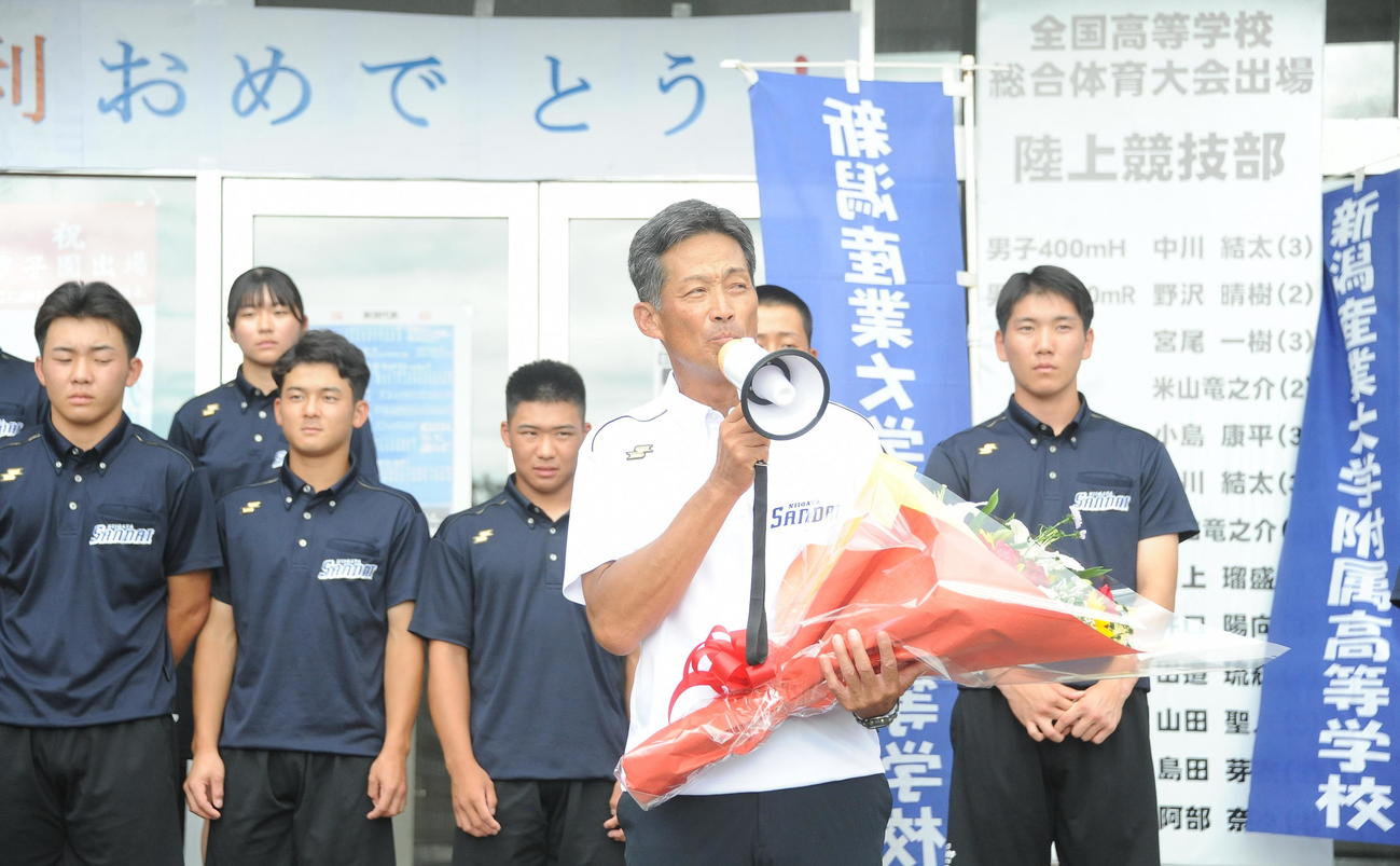 集まった教職員や保護者らにお礼を述べる吉野監督（手前）ら選手たち（撮影・小林忠）