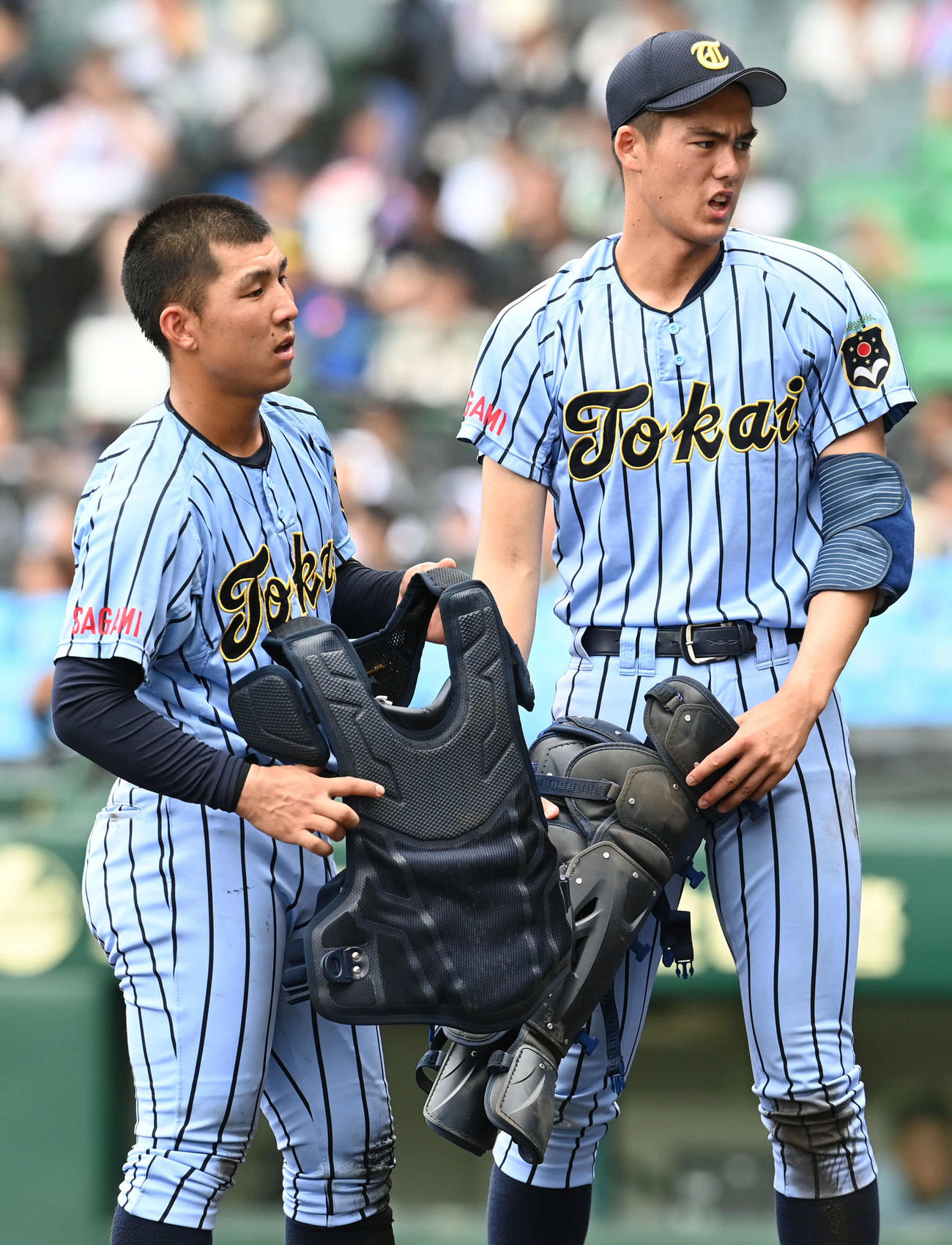 東海大相模対広陵　降板した東海大相模・藤田（右）は防具を着ける木村は手伝う（撮影・山崎安昭）