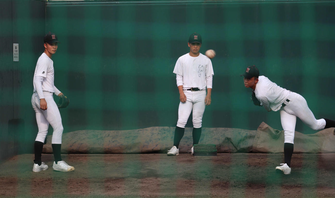 開幕前の練習で、広陵・山口の投球を見つめる、同学年の高尾（写真中央）と2年生の堀田（写真左）（撮影・中島麗）