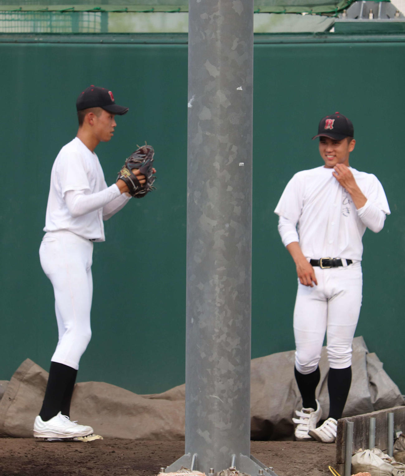 開幕前の練習で、広陵・山口の投球練習の間に会話をかわす、同学年の高尾（撮影・中島麗）