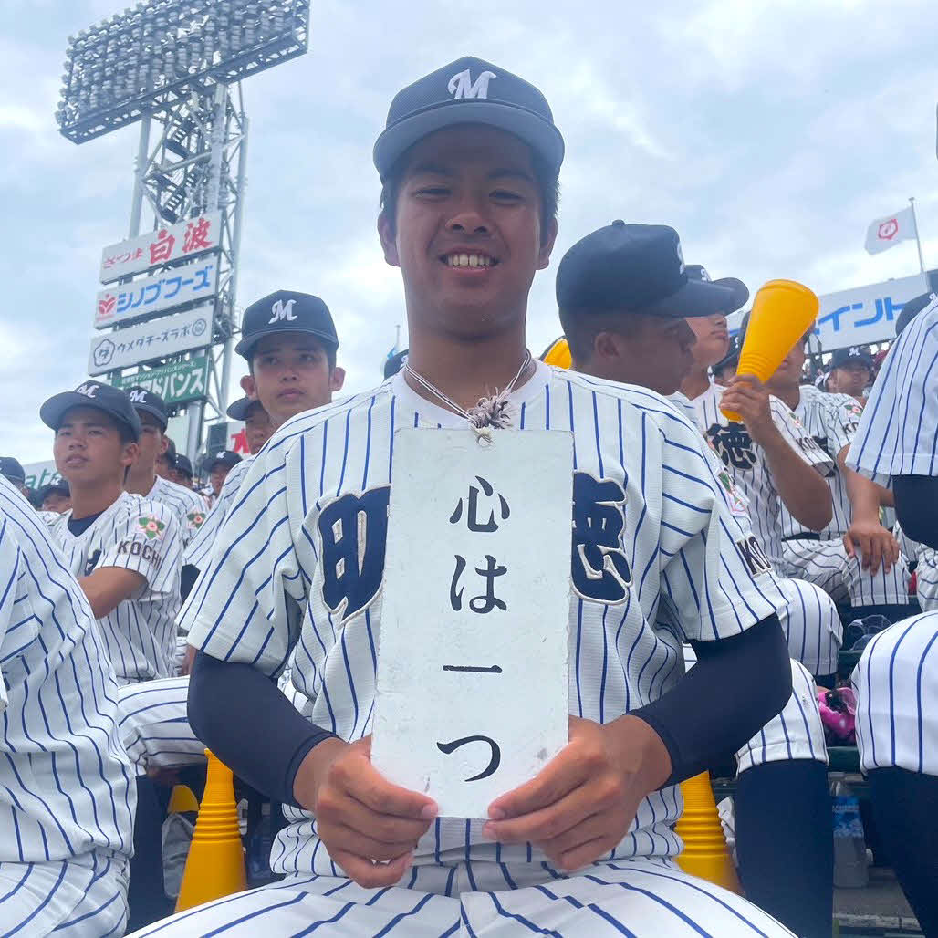 「心は一つ」と記され、裏面には選手の名前が入った応援札を持つ、明徳義塾の応援団長・柴田恭吾内野手（3年）