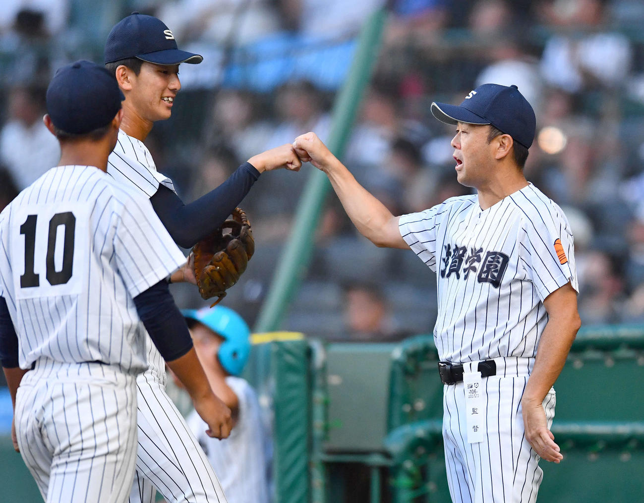滋賀学園対霞ケ浦　7回裏終了後、岩井（左から2人目）とグータッチを交わす滋賀学園・山口監督（撮影・岩下翔太）