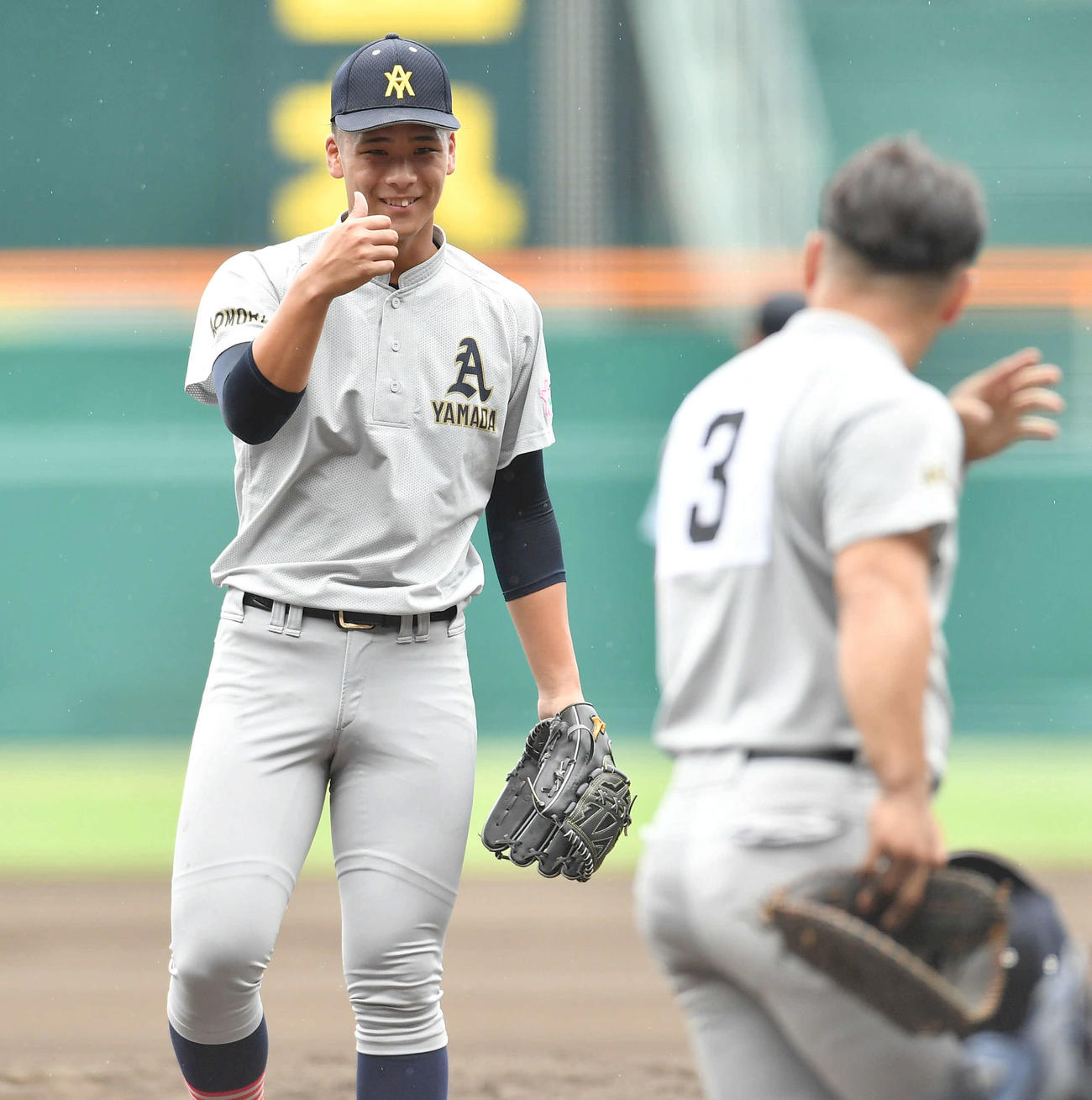 滋賀学園対青森山田　6回表滋賀学園無死一、二塁、送りバントを打ち上げた岡田の打球を好捕した一塁手の原田（右）にサムアップポーズを見せる青森山田・関（撮影・岩下翔太）