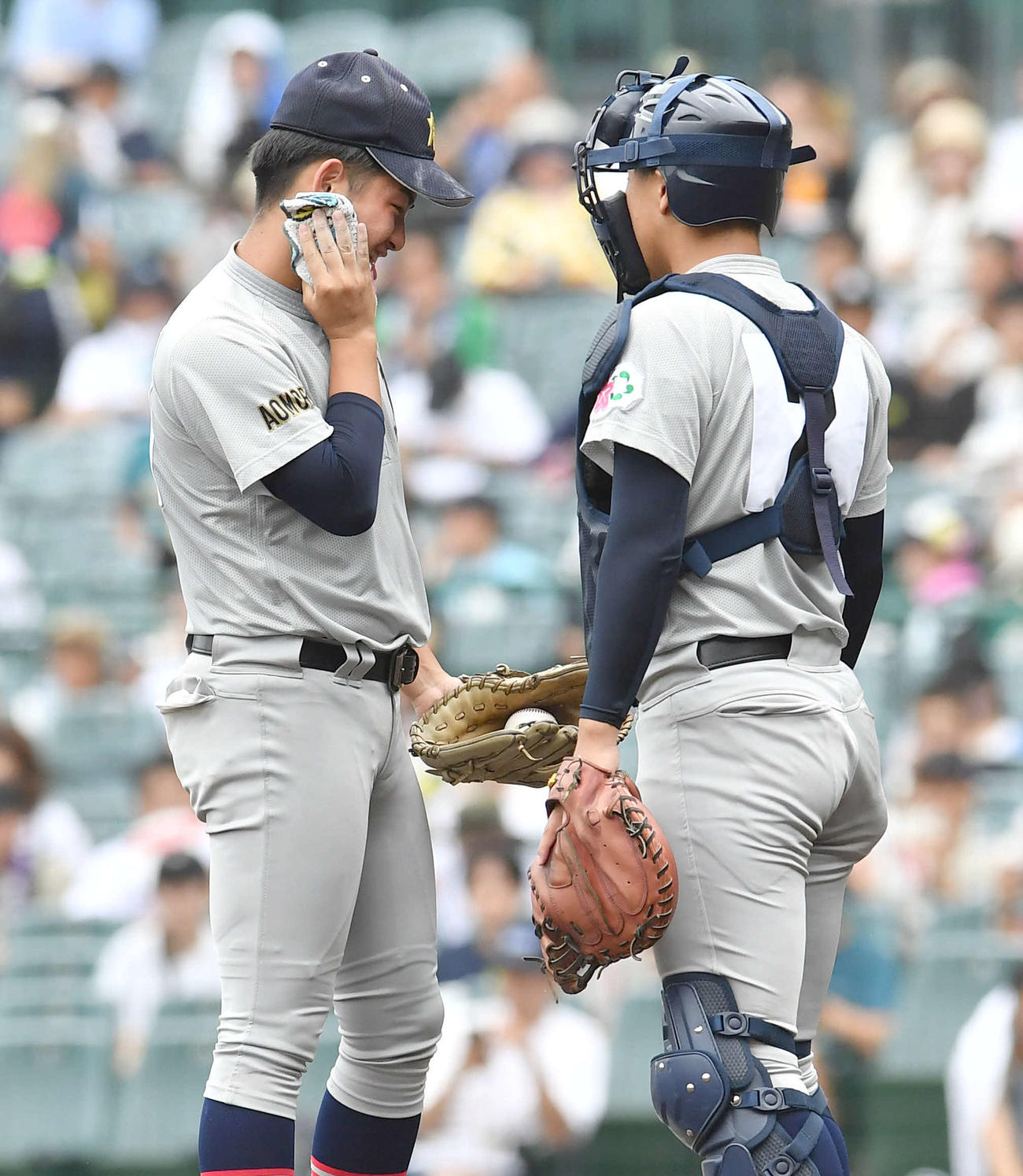 滋賀学園対青森山田　1回表滋賀学園2死二塁、打席に岡田を迎える場面で、タオルで汗をぬぐいながら橋場（右）と話す青森山田・下山（撮影・岩下翔太）