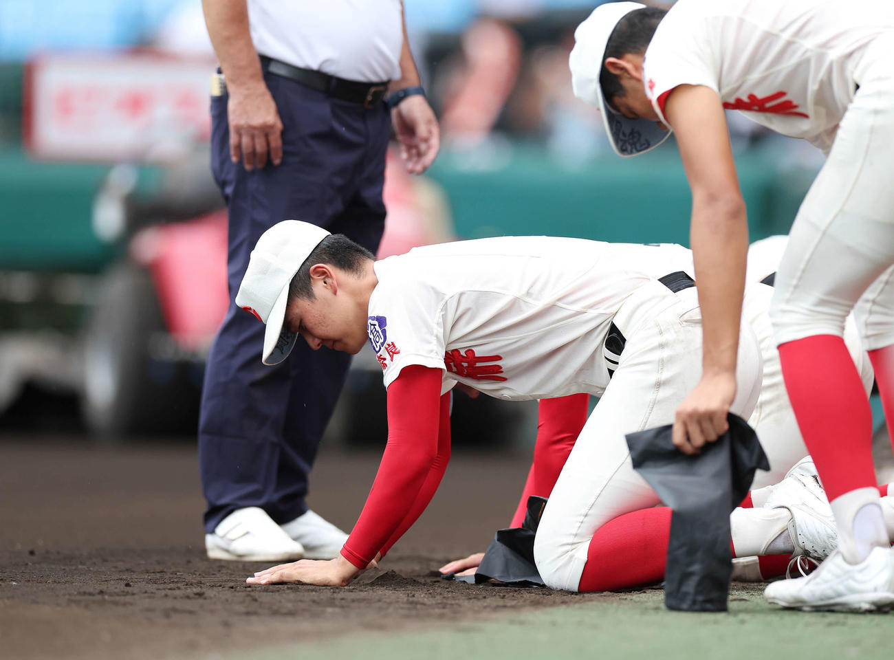 京都国際対智弁学園　京都国際に敗れ、甲子園球場の土を集める智弁学園・田近（撮影・前田充）