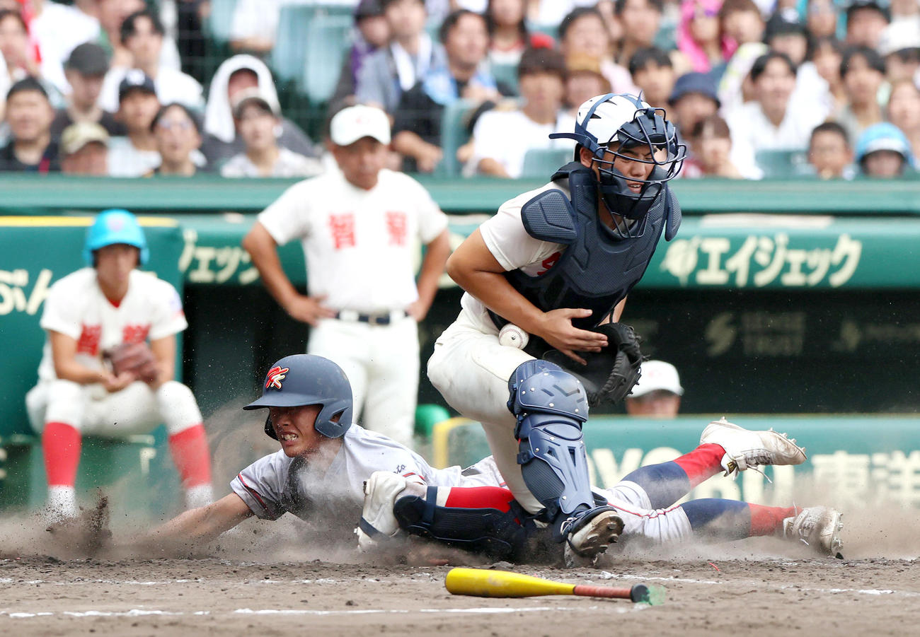 智弁学園対京都国際　4回裏京都国際2死二塁、西村の右前適時打で生還する二走・奥井。右は捕手・山崎（撮影・上山淳一）