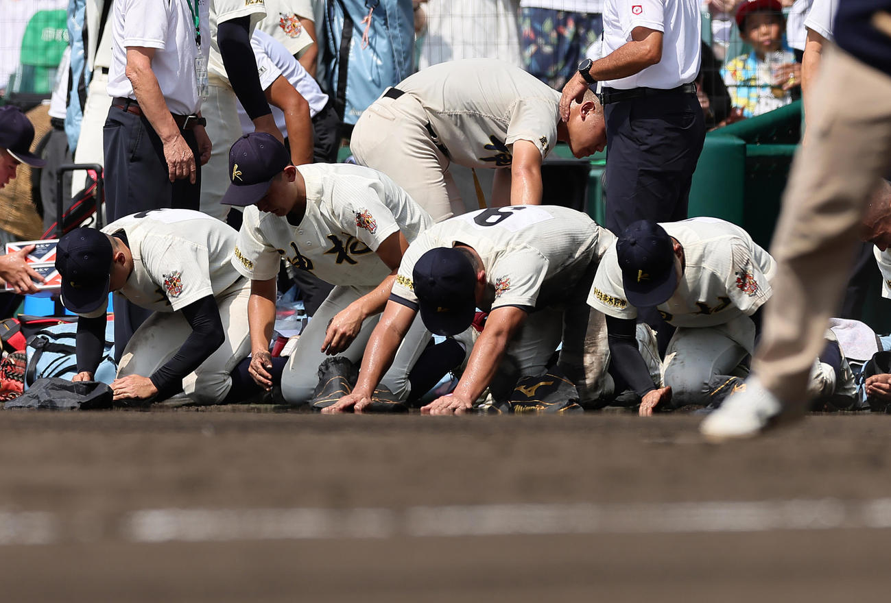 神村学園対関東第一　関東第一に敗れ、甲子園の土を拾う神村学園・正林（中央右）ら（撮影・足立雅史）