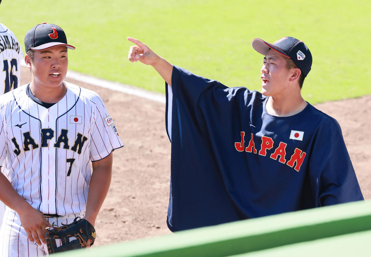 練習試合・U18日本代表対関西学生野球連盟選抜　6回の守備を終えたナインをベンチ前で出迎えるU18日本代表・中崎。左は花田（撮影・上山淳一）
