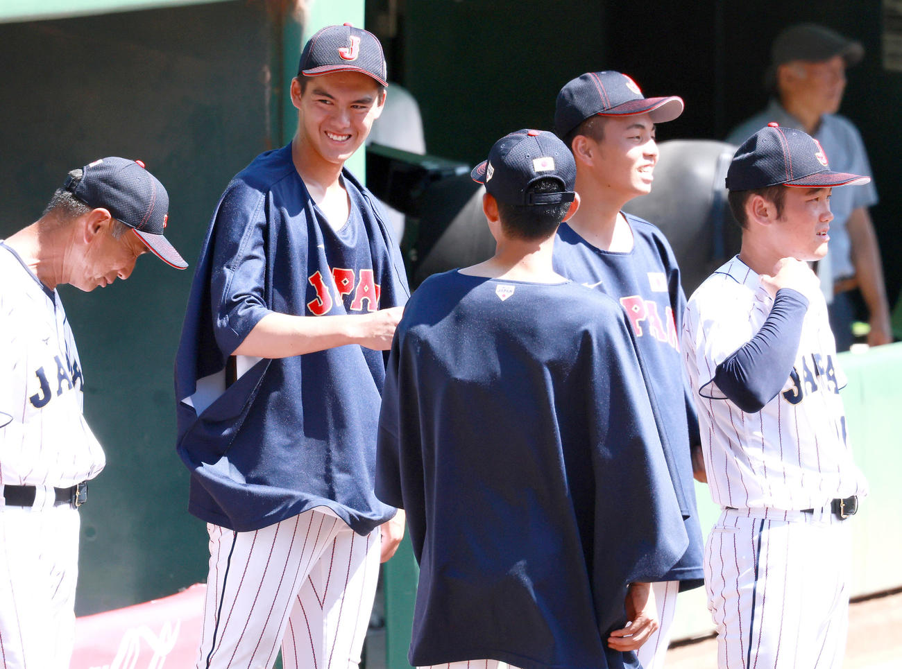 練習試合・U18日本代表対関西学生野球連盟選抜　3回の登板を終えたU18日本代表・藤田（左から2人目）はベンチ前で荒井ヘッドコーチ（左）と笑顔で話す（撮影・上山淳一）