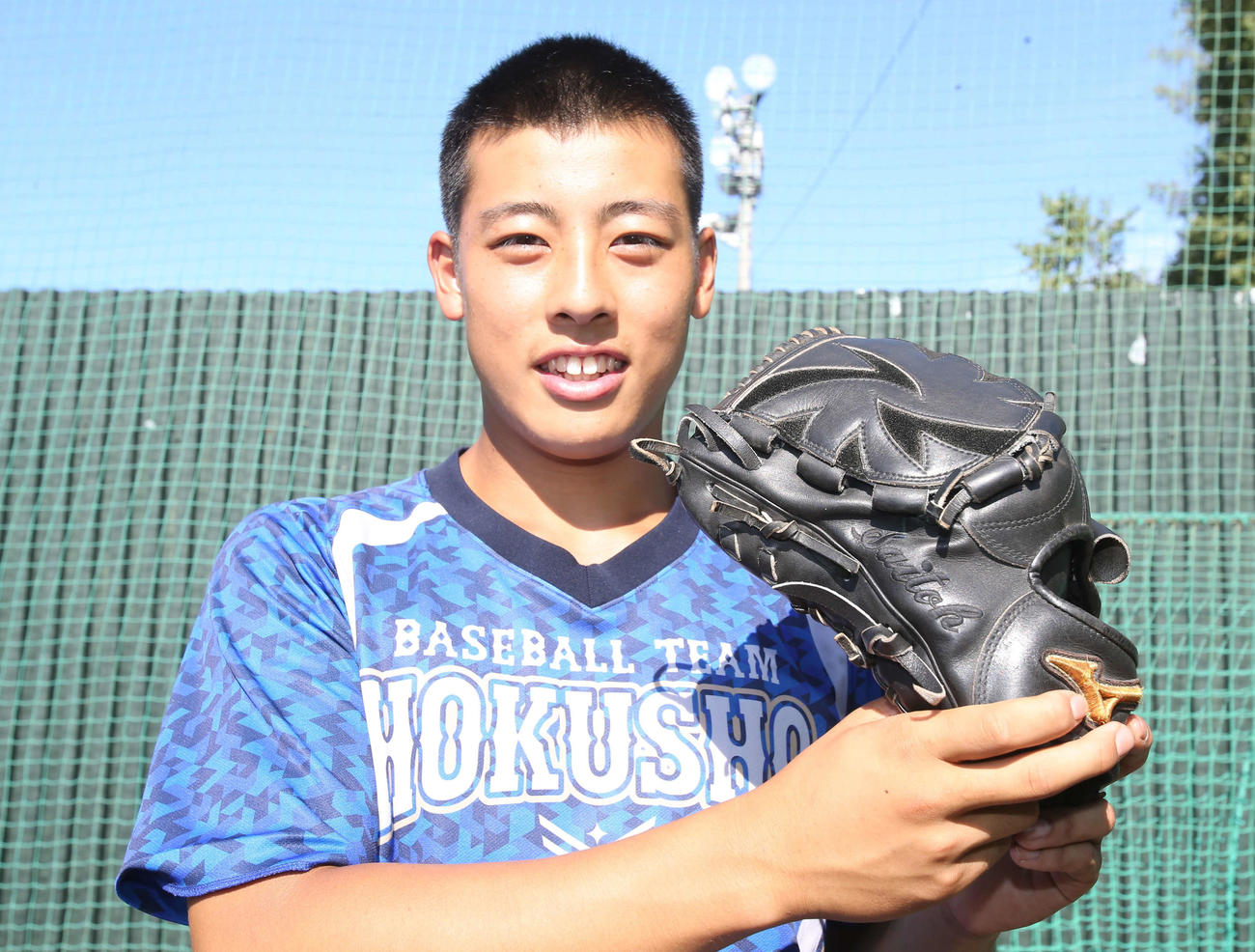 北照の高橋投手は、北照OBで中日の斎藤投手からもらったグローブを手に笑顔（撮影・中島洋尚）